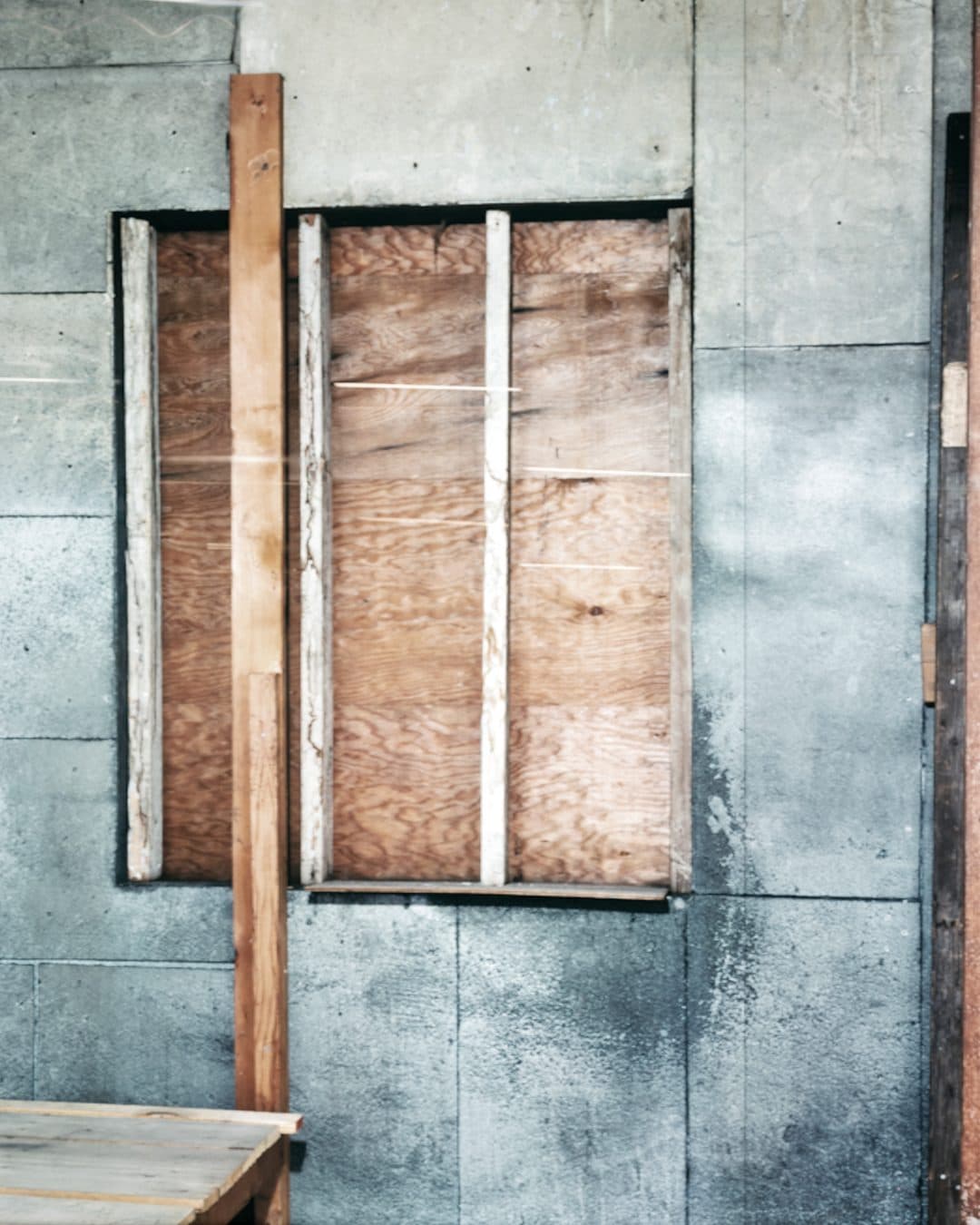 Abstract architectural study — weathered concrete and timber panels in quiet light